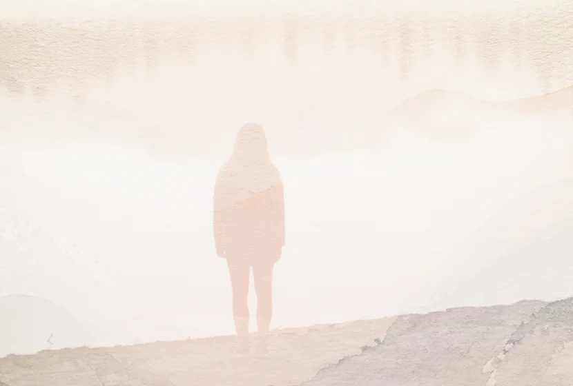 A silhouetted person standing beside a pale lake in a soft layered landscape